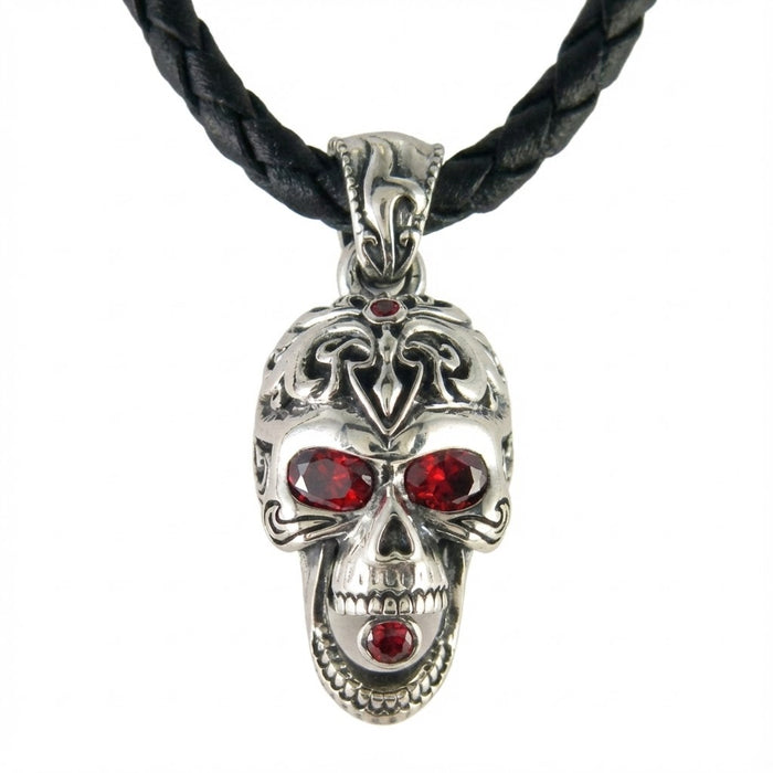 Silver skull pendant with red stone in mouth attached to braided leather necklace