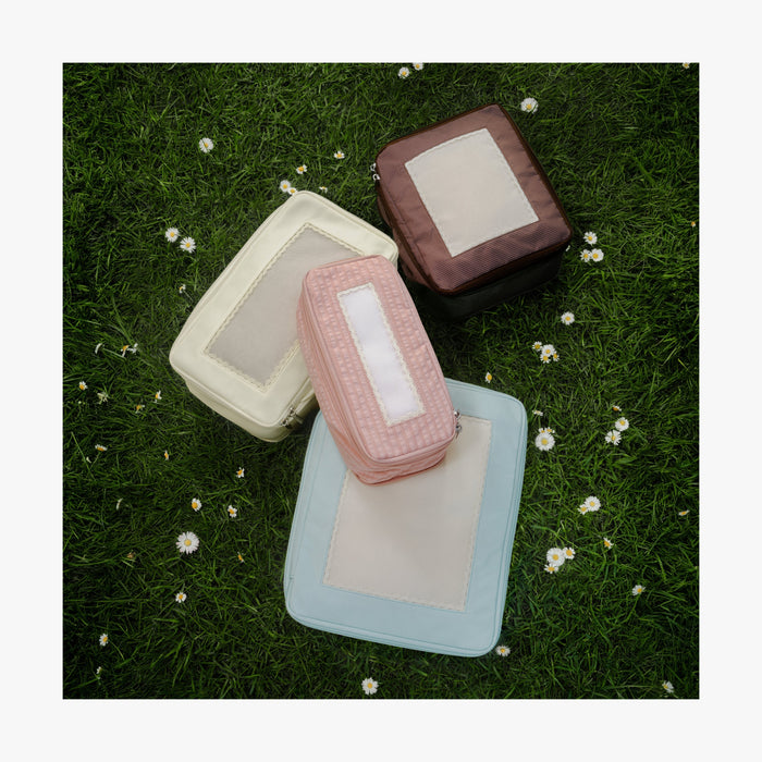 Set of Four / Multi | Four Monos x Reformation packing cubes Multi color laid on green grass with daisies