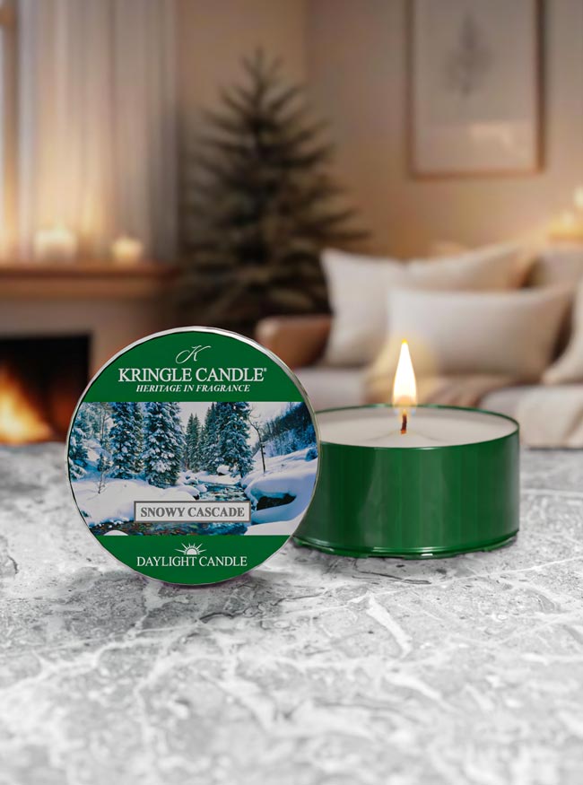 Snowy Cascade candle with Kringle Candle packaging on a textured surface with a cozy indoor background.