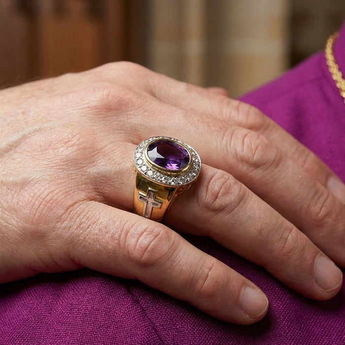 Men's gold amethyst bishop ring worn on hand over purple clergy vestment showing cross detail