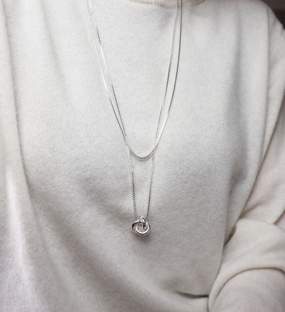 Silverhalsband med en stor silverknut i lång silverkedja. Kombinerat med en kortare kedja.
