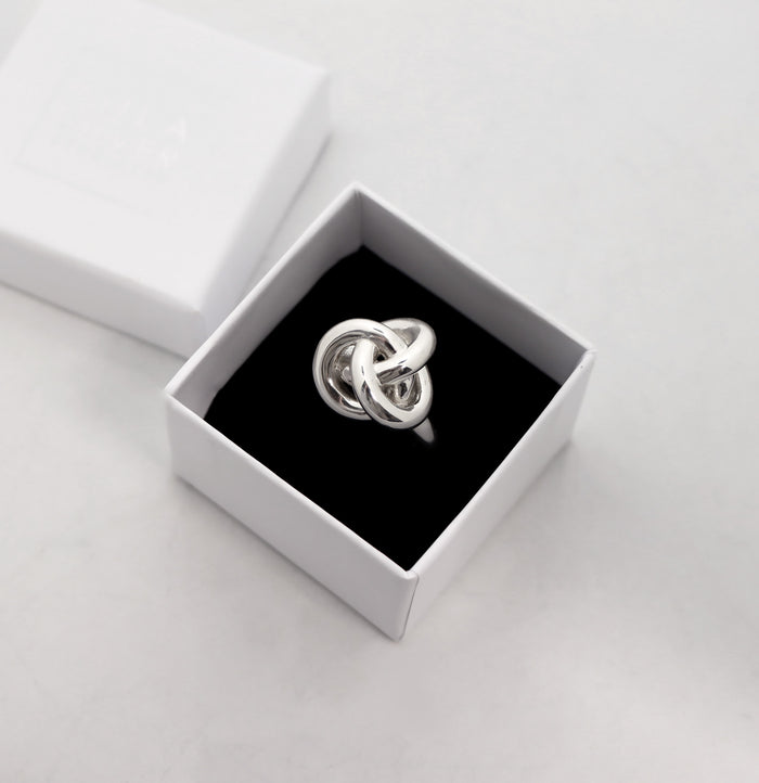 Ring med stor silverknut placerad i en vit ringask från Mila Silver