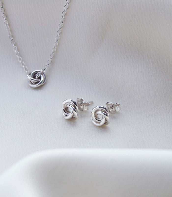 Silverknutar till öronen och silverhalsband med knut.