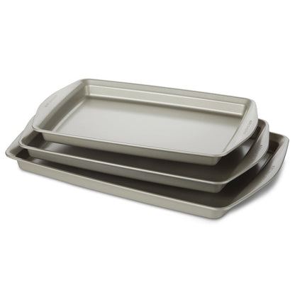 Introducing the "3-Piece Nonstick Jumbo Sheet Pan Set," a collection of three gray baking trays designed to nestle together perfectly. Crafted from heavy gauge steel, these nonstick cookie pans ensure durability and even heat distribution. They are oven safe, meeting all your baking needs with reliable performance every time.