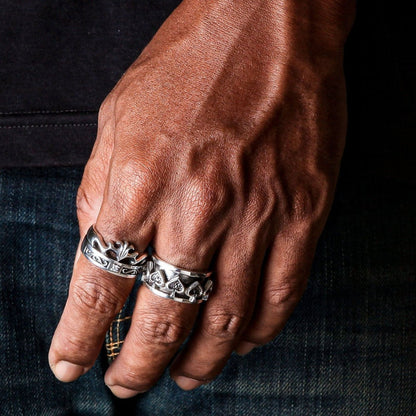 Two sterling silver rings stacked on hand featuring ace of spades spinner ring and crown band