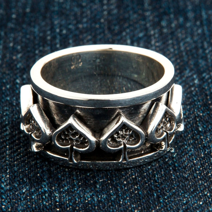 Ace of spades sterling silver spinner ring on blue denim showing oxidized detail and polished edges