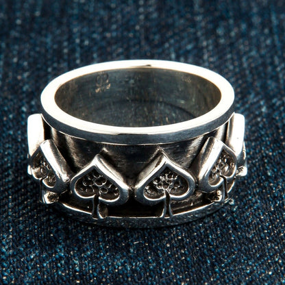 Ace of spades sterling silver spinner ring on blue denim showing oxidized detail and polished edges