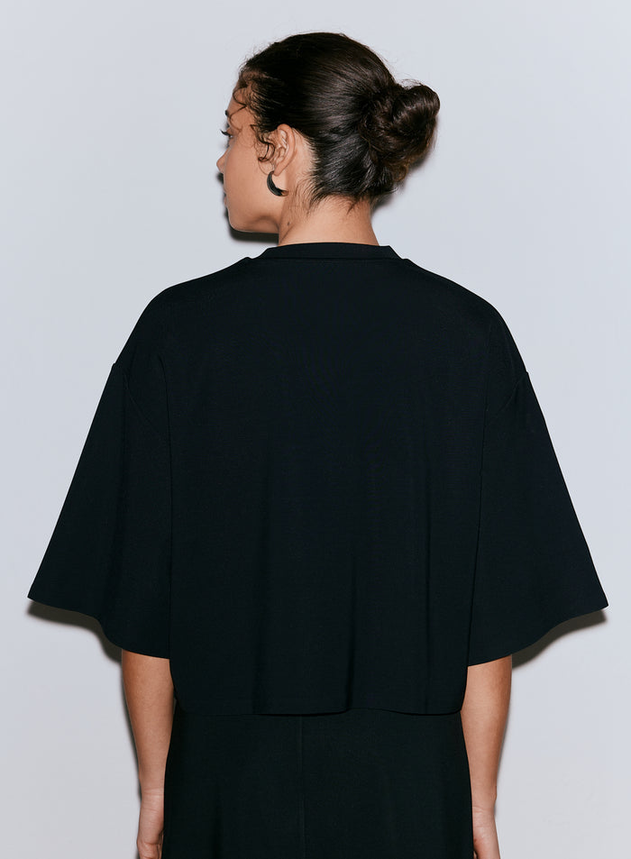 Woman seen from behind wearing a black Luxe Boxy Short Sleeve top. [M-170CM]