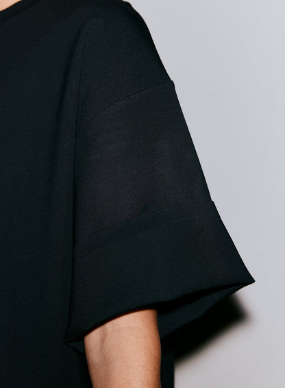 Close-up of a person's arm wearing a black Luxe Boxy Short Sleeve top [M-170cm]