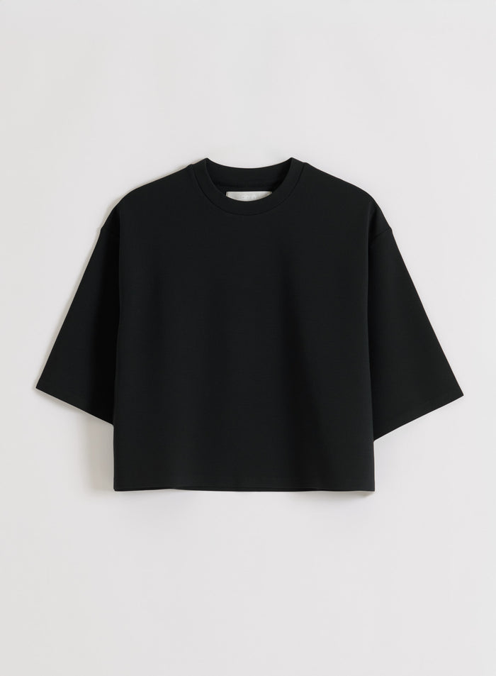 Flat lay of a black aim'n Luxe Boxy Short Sleeve top