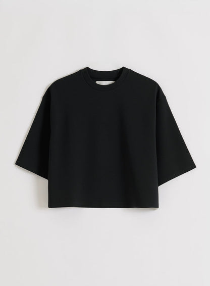 Flat lay of a black aim'n Luxe Boxy Short Sleeve top