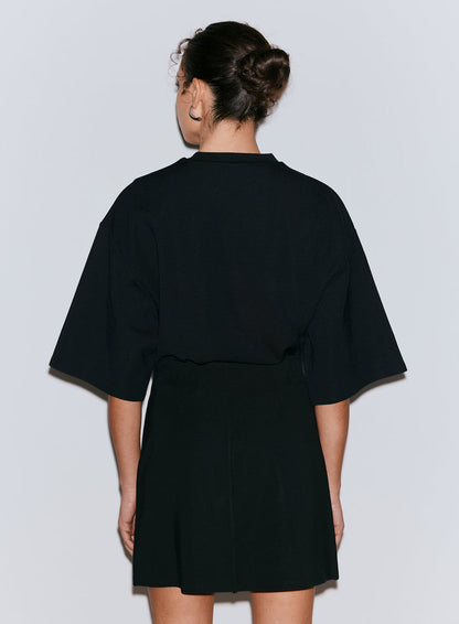 Back view of a woman wearing a black Luxe Mini Skort [36-170CM]