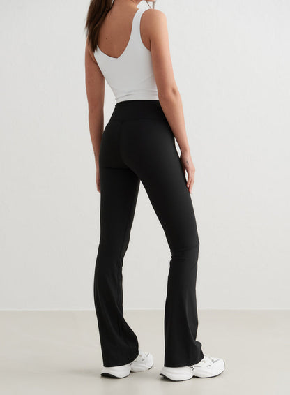 Black high-waisted Sense Flare Tights from aim'n featuring a flared leg and squat proof fabric, back view.
