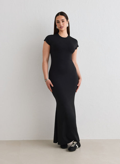 A woman wearing a black Sense Mermaid Cap Sleeve Dress from aim'n [L-174cm]