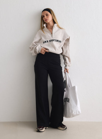 Model wearing Black Sense Pants and a beige half-zip sweatshirt, holding a white tote bag [M-170cm]