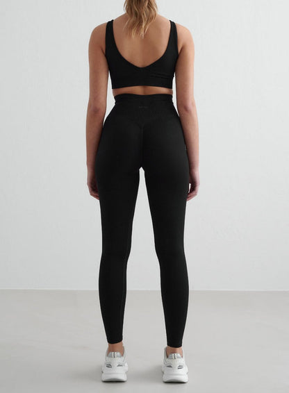 Woman wearing black Shape Seamless Tights from aim'n, seen from the back. [S - 175 cm]