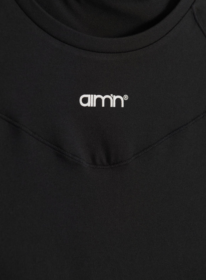 Black Soft Basic Short Sleeve top shown in a close-up with a white printed aim'n logo and round neck.