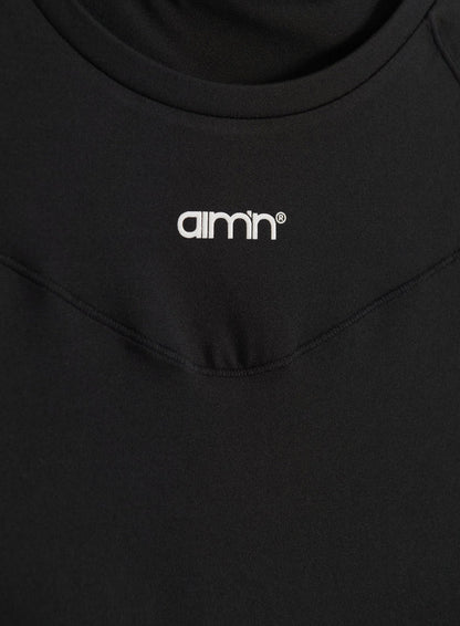 Black Soft Basic Short Sleeve top shown in a close-up with a white printed aim'n logo and round neck.