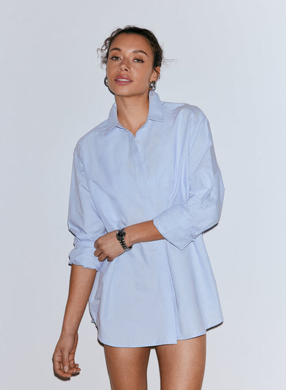 Woman posing in an oversized light blue Oxford shirt with rolled-up sleeves [M-170cm]