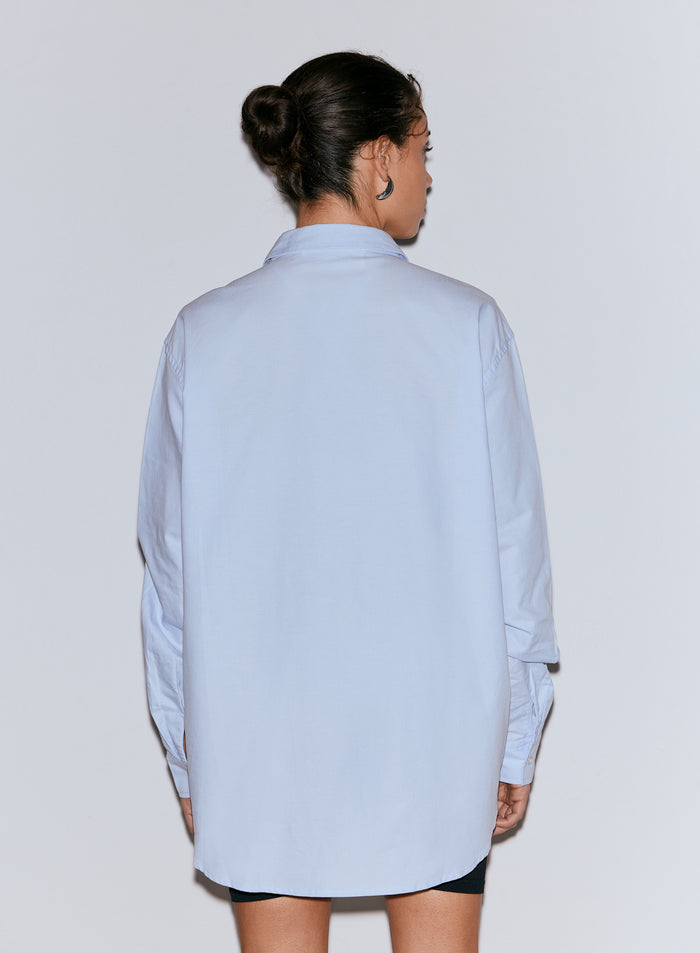 A person from behind wearing a light blue oversized Oxford shirt [M-170cm]