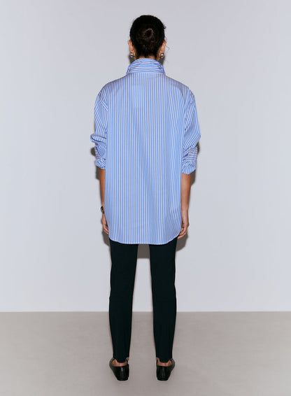 A model seen from the back wearing a blue and white striped poplin shirt with rolled-up sleeves and dark trousers [M-170CM]