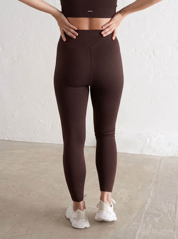 Rear view of cacao ribbed seamless maternity tights by aim'n with a high-waisted design.