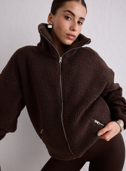 A woman wearing a brown Cacao Pile Jacket with a high collar and front zipper [M-174cm]