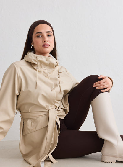Woman sitting on the floor wearing a Cafe Au Lait Rain Jacket by aim'n [M-174cm]