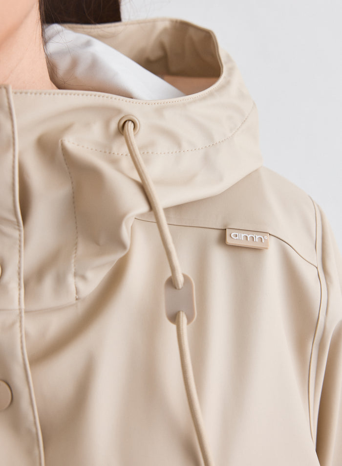 Close-up of the hood and logo detail on the Cafe Au Lait Rain Jacket [M-174cm]