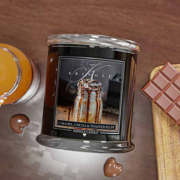 Kringle Candle with a caramel, cocoa, and toasted fluff flavor on a wooden surface.