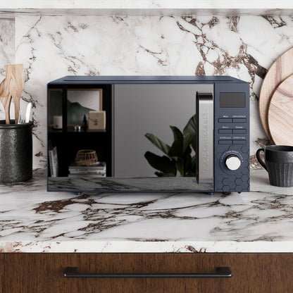 Navy microwave oven on a marble countertop with a kitchen setting.