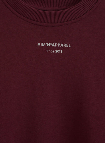 Cherry Apparel Terry Sweatshirt featuring a silver aim'n logo print and a ribbed round neckline.