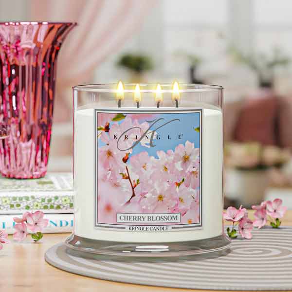Kringle Candle cherry blossom 4-wick lit candle on a table with a blurred background