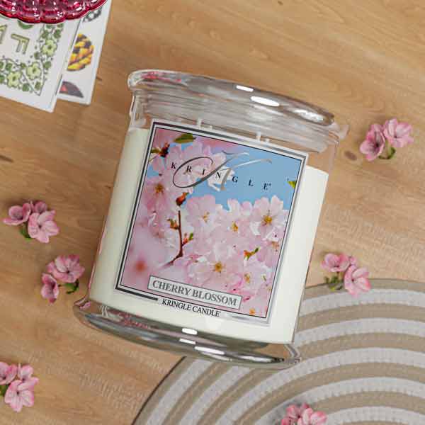 Kringle Candle cherry blossom 4-wick lit candle on a table with a blurred background