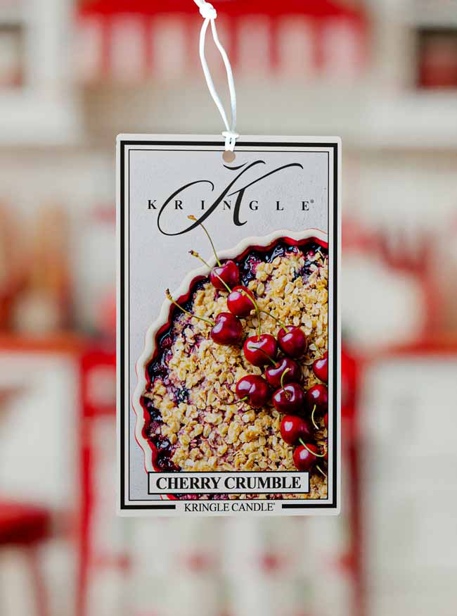 Kringle Candle Cherry Crumble air freshener tag with a blurred background