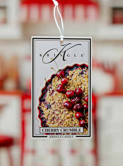 Kringle Candle Cherry Crumble air freshener tag with a blurred background