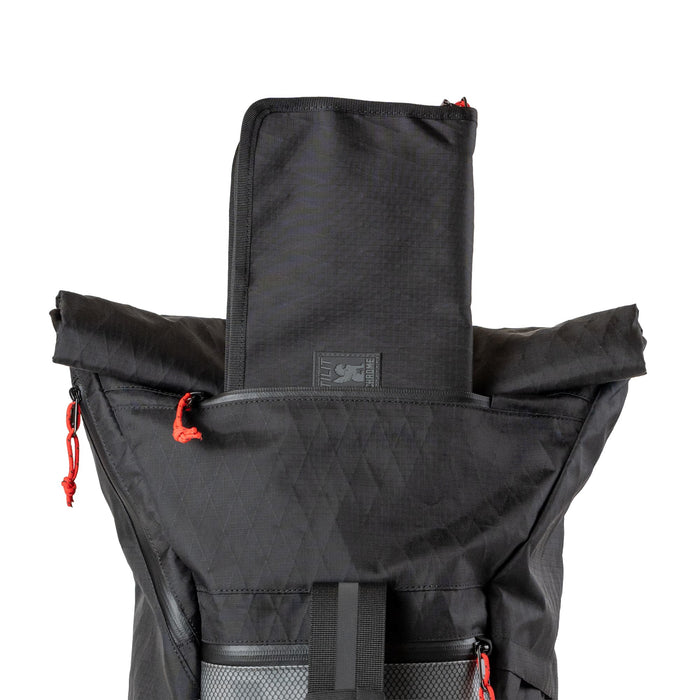 The knife roll coming out of the zipper pocket in the Chrome x Tilit 29L Chef Pack
