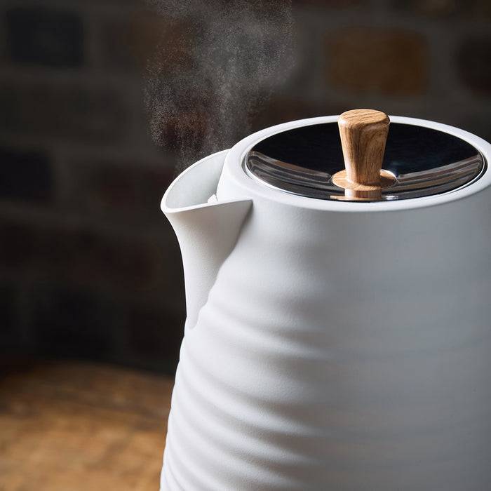 White electric kettle with a wooden handle on a dark background