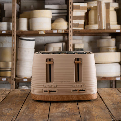 Beige toaster on a wooden table with shelves of white pottery in the background