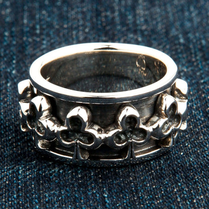 Club pattern sterling silver spinner ring on denim fabric showing polished finish