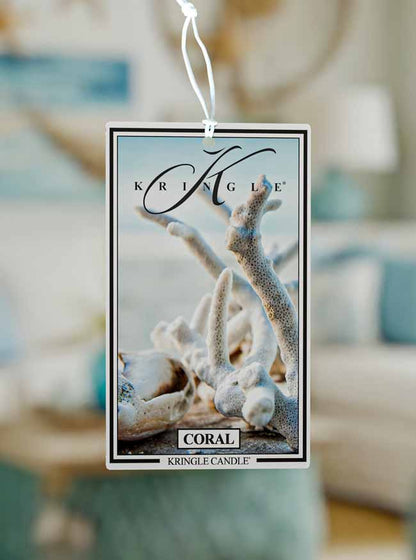 Kringle Candle coral air freshener tag with blurred background