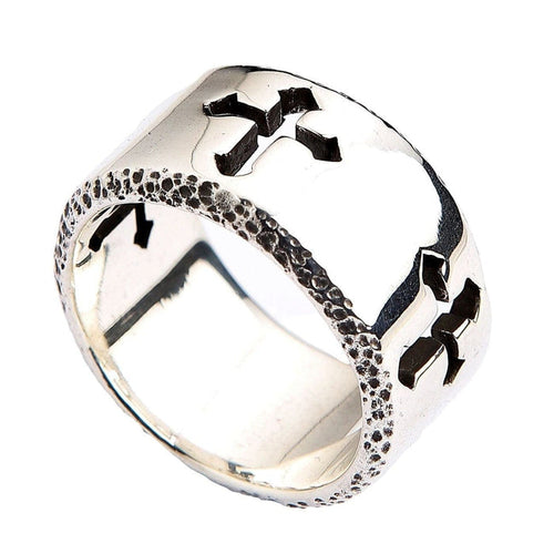 A wide sterling silver cut-out cross ring with a brilliant polished finish and rugged, textured, darkened edges.