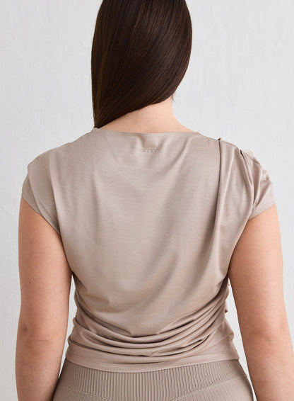 Back view of a woman wearing a Dark Clay Luminous Draped Short Sleeve by aim'n [L-174cm]