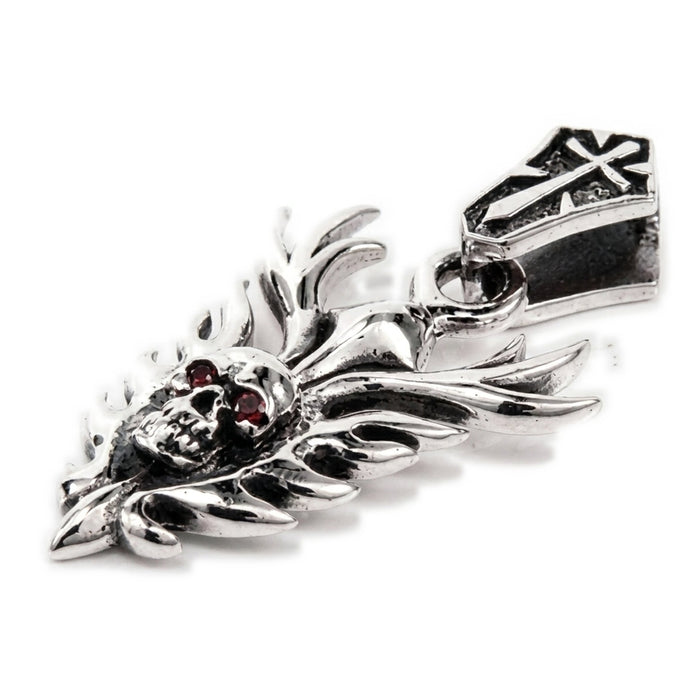 Macro detail of the skull face on the sterling silver pendant showing deep-red garnet cabochon eyes