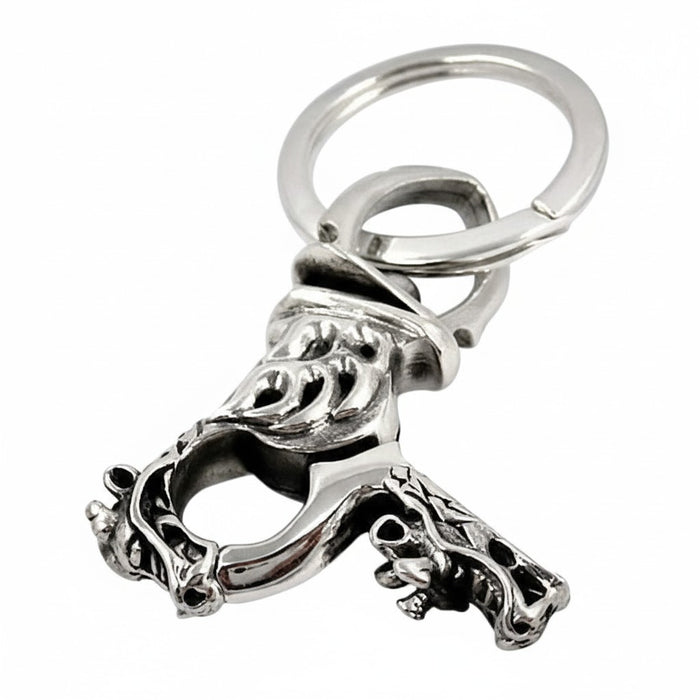 An angled view of the gothic dragon keychain, showing the flame engraving on the clasp.