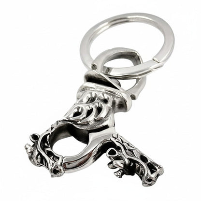 An angled view of the gothic dragon keychain, showing the flame engraving on the clasp.