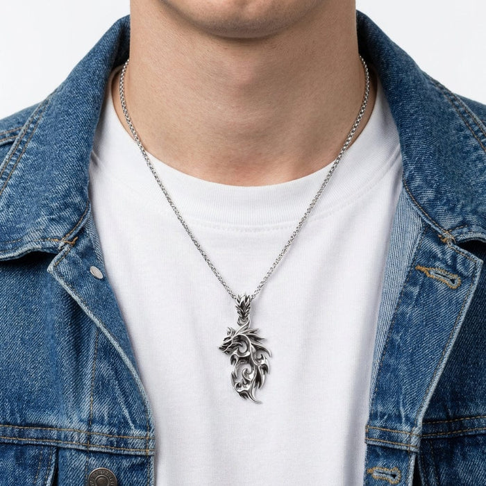 Silver flame dragon wolf pendant necklace with intricate tribal swirl design worn on a silver chain by a man in a white t-shirt and blue denim jacket