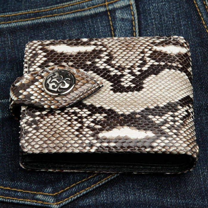 A classic biker snake wallet, meticulously handcrafted from cobra leather, shown resting on a dark denim background.