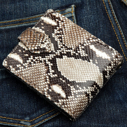 Cobra scales in brown and cream across the closed bifold, tab clasp at the left and hardware at the corner.