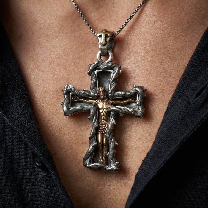 Close-up of handcrafted sterling silver crucifix pendant with golden Jesus figure worn on man's chest